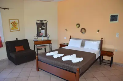 a bedroom with a bed and a chair at Melia Studios in Kato Daratso