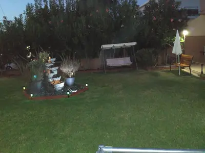 a garden with a table with plants and a gazebo at Melia Studios in Kato Daratso