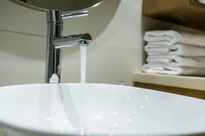 a bathroom sink with a water faucet and towels at Kamartos Villa 1 in Áyios Yeóryios