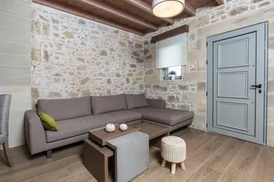 a living room with a couch and a door at Kamartos Villa 1 in Áyios Yeóryios