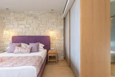 a bedroom with a bed and a brick wall at Sissy Luxury Villa Chania in Plataniás