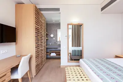 a hotel room with a bed and a desk and a bedroom at Sissy Luxury Villa Chania in Plataniás