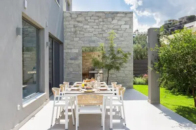 a white dining table and chairs on a patio at Sissy Luxury Villa Chania in Plataniás