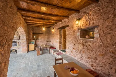 an old stone house with a kitchen and dining room at ARADENA TRADITIONAL House 2 in Arádhaina