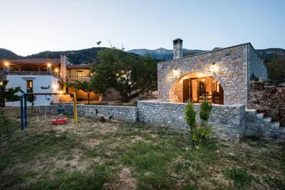 a stone house with a stone wall in a yard at ARADENA TRADITIONAL House 2 in Arádhaina