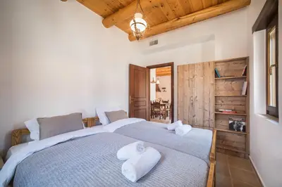 two beds in a bedroom with wooden ceilings at ARADENA TRADITIONAL House 4 in Arádhaina
