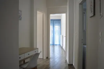 a white room with a desk and a chair at Botonis Bright Spacious Apartment in Chania Town