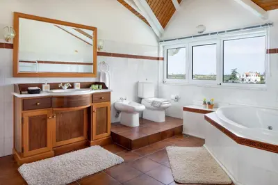 a bathroom with a tub and a toilet and a sink at Villa Elihrisos in Chorafakia