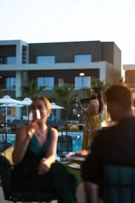 a woman standing in front of a pool with a microphone at Myrion Beach Resort & Spa - Adults Only in Gerani Chanion