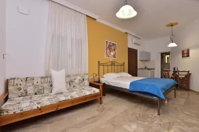 a bedroom with a bed and a couch at Paleochora Elizabeth Apartments in Palaiochóra