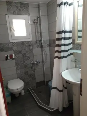 a bathroom with a shower and a toilet and a sink at Paleochora Elizabeth Apartments in Palaiochóra
