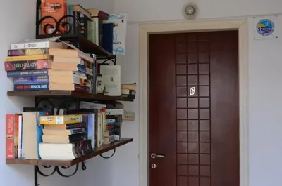 a book shelf filled with books next to a door at Paleochora Elizabeth Apartments in Palaiochóra