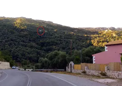 a red object is flying over a road at Polios in Avdhoulianá