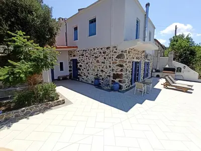 a villa with a patio in front of a building at Polios in Avdhoulianá