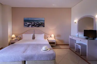 a bedroom with a bed with a hat on it at Hotel Poseidon in Palaiochóra