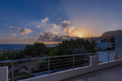 a view of the beach at sunset from a balcony at Hotel Poseidon in Palaiochóra