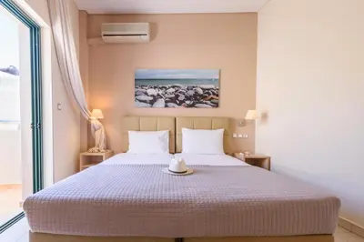 a bedroom with a bed with a hat on it at Hotel Poseidon in Palaiochóra