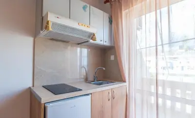 a small kitchen with a sink and a window at Nikos Rooms in Palaiochóra