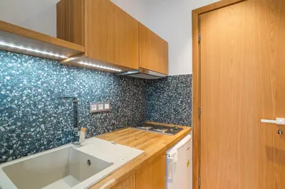 a kitchen with a sink and wooden cabinets at Manos Studios in Palaiochóra