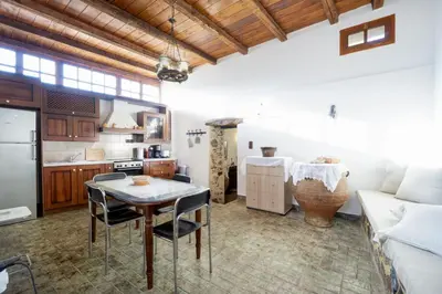 a kitchen and living room with a table and a couch at Villa Talos in Palaiochóra