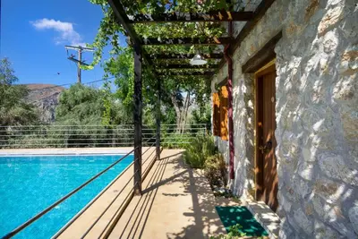 a house with a swimming pool next to a building at Villa Talos in Palaiochóra