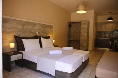 a bedroom with a large bed with two white pillows at Kosmos A.G.K Studios-Apts in Kato Daratso