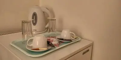 a table with two cups and a tea kettle at Alexandra Hotel in Kalamaki Chanion
