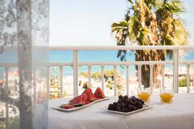 a table with two plates of fruit on a balcony at Hermes Sea View in Stalos