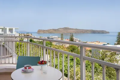 a table and chair on a balcony with a view of the ocean at Hermes Sea View in Stalos