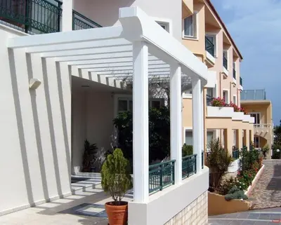 a white pergola on the side of a building at Alexia Beach Hotel in Agia Marina Nea Kydonias