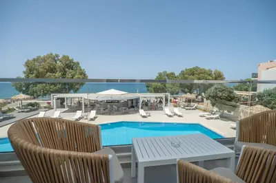a patio with a swimming pool and chairs and a table at Alexia Beach Hotel in Agia Marina Nea Kydonias