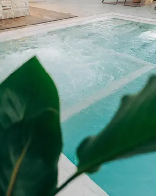 a person holding an umbrella in front of a swimming pool at Miramare Boutique Apartments in Plataniás