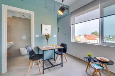 a dining room with a table and chairs and a window at Koukou Central Apt -Fast WIFI- 5' to Old Town in Chania Town