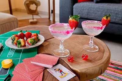 two wine glasses with strawberries on a wooden table at LOTOS - Luxury Apartments in Kounoupidhianá