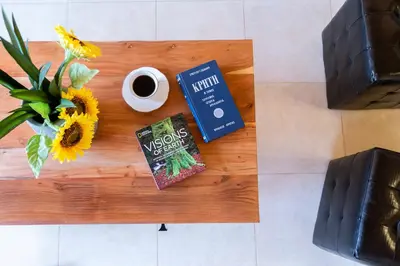 a book and a cup of coffee on a table at LOTOS - Luxury Apartments in Kounoupidhianá