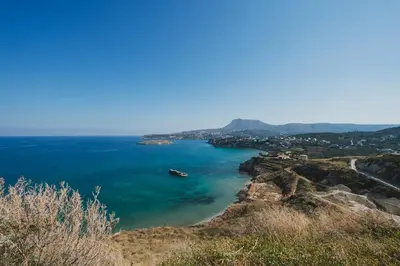 a boat in a large body of water at Karavos View - An artists' hideaway Paradise in Kalyves