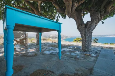 a blue table sitting next to a tree at Karavos View - An artists' hideaway Paradise in Kalyves