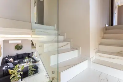 a staircase in a house with a blue couch at Villa Lulla in Beritianá