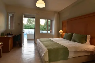 a bedroom with a large bed and a bathroom at Okeanis II in Kato Daratso