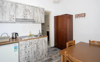 a kitchen with wooden cabinets and a wooden table at Maria's Hotel in Palaiochóra