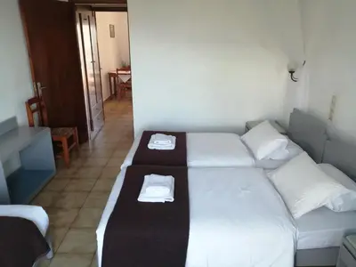 a room with two beds with white sheets and towels at Oasis Apartments in Frangokastello