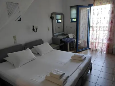 a bedroom with a large white bed with towels on it at Oasis Apartments in Frangokastello