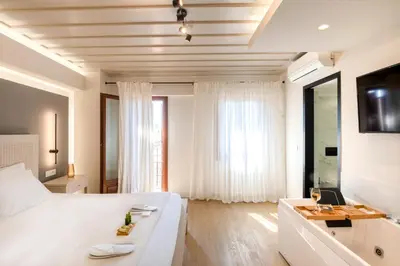a bedroom with a large white bed and a desk at Hanim Boutique Hotel in Chania Town