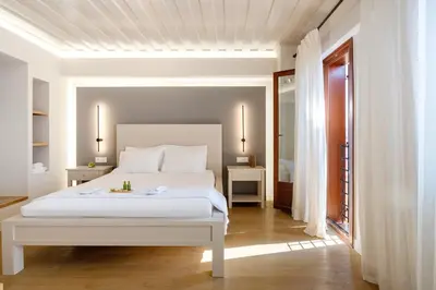 a white bedroom with a white bed and a door at Hanim Boutique Hotel in Chania Town
