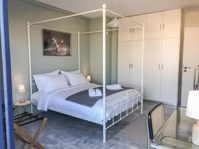 a bedroom with a four poster bed and a chair at Sigma city loft, in the heart of Chania in Chania Town