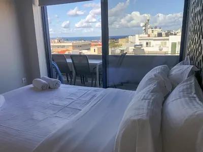 a bedroom with a bed and a large window at Sigma city loft, in the heart of Chania in Chania Town