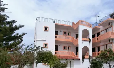 an apartment building with orange balconies and trees at Pentari in Stalos