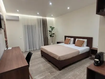 a bedroom with a bed and a table and a desk at Vasiliki Apartments in Plataniás