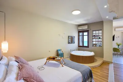 a bedroom with a large bed and a tub at Thalassa mou Seafront suite in Chania Town