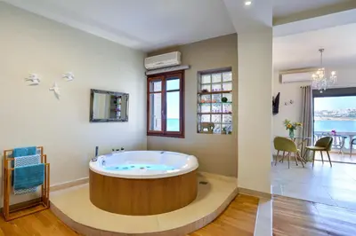 a large bathroom with a tub in the middle of a room at Thalassa mou Seafront suite in Chania Town
